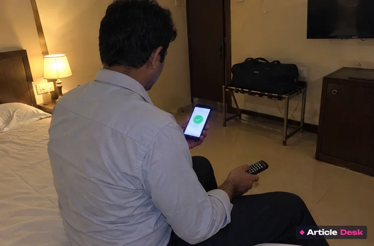 A man in a hotel room looking at a payment done screen on his phone